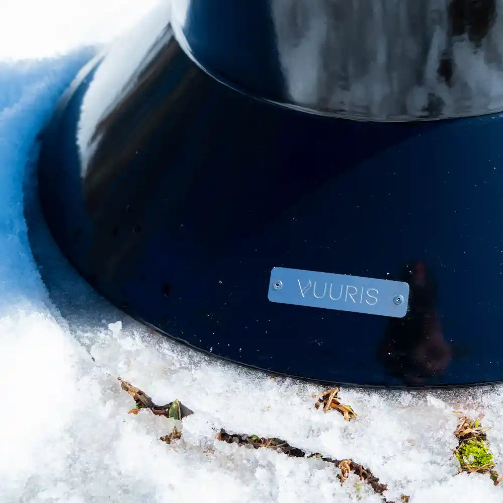 A macro close up shot of the large base of the black Vuuris Onyx with the Vuuris brand nameplate clearly visible on a snow ground