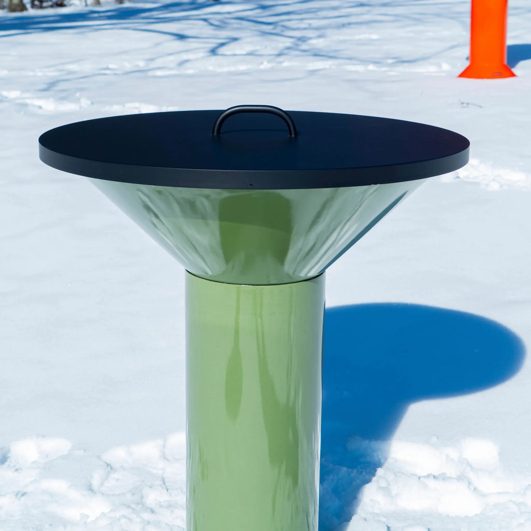 Vuuris matte black powder-coated steel lid, paced on the green Vuuris Sage on the large base with a snowy background